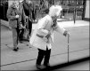 Old woman with stick crossing road Exeter GX7 P1140316.JPG